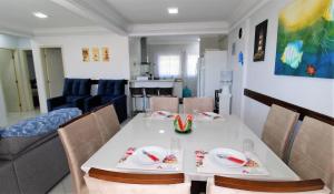 comedor y sala de estar con mesa y sillas en 1010 - Residencial Solar das Bromélias Apto 233 en Bombinhas
