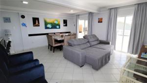 - un salon avec un canapé et une chaise dans l'établissement 1010 - Residencial Solar das Bromélias Apto 233, à Bombinhas
