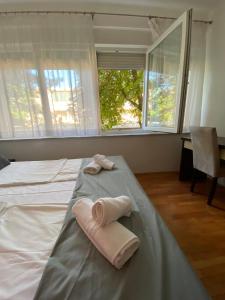 2 handdoeken op een bed in een kamer met een raam bij Apartman Nika in Mostar