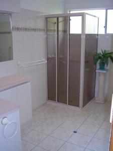 een badkamer met een douche en glazen deuren bij 22 Weemilah Drive Pambula Beach in Pambula Beach