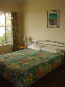 een slaapkamer met een bed met een kleurrijke deken bij 22 Weemilah Drive Pambula Beach in Pambula Beach