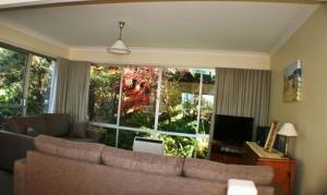 Pambula Beachにある22 Weemilah Drive Pambula Beachのソファと大きな窓のあるリビングルーム