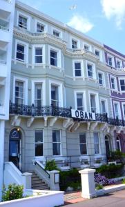 a large white building with a sign on it at OYO Oban Hotel in Eastbourne