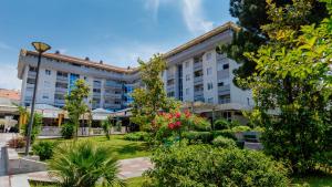 a building with a garden in front of it at Apartment Sahala in Tivat