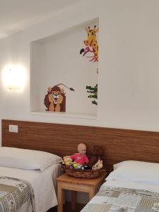 een slaapkamer met 2 bedden en een mand met speelgoed op een tafel bij Amoroso's house, affittacamere in Caramanico Terme