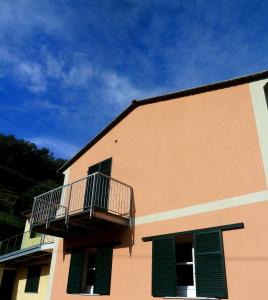 a building with green shutters and a balcony on it at Al Molino delle Ghiare in Levanto