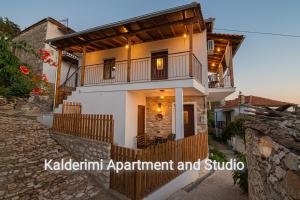 a white house with a balcony and a staircase at Kalderimi Studio in Sotír