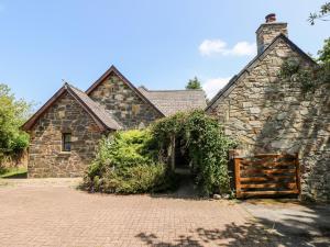 an old stone house with a gate in a driveway at Banc Y Capel in Newport