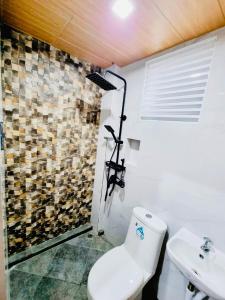 a bathroom with a toilet and a sink at Rvenue apartelle in Lucban
