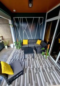 a patio with couches and yellow pillows at Rvenue apartelle in Lucban