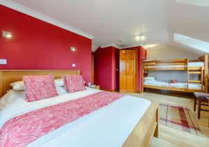 a bedroom with a large bed with red walls at Beudy Bach in Silian