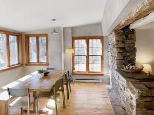a dining room with a wooden table and a stone wall at Breezy Hill 3BR Modern & Quiet Home in Catskills in Accord