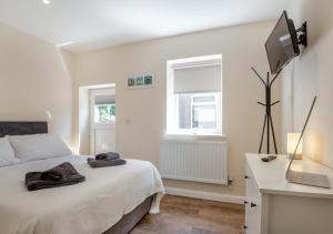 a bedroom with a bed with towels on it at Yr Hen Barlwr in Llanddyfnan