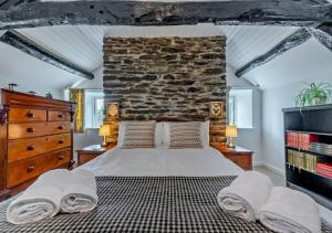 ein Schlafzimmer mit einem großen Bett und einer Steinmauer in der Unterkunft Old Vicarage Cottage in Llangeler