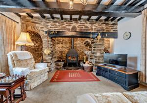 LlangelerにあるOld Vicarage Cottageのリビングルーム(ソファ、暖炉付)