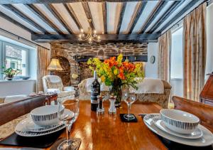 a living room with a wooden table with flowers on it at Old Vicarage Cottage in Llangeler