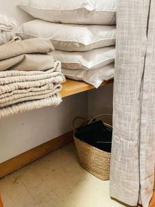 a room with a shelf with towels and a basket at Breezy Hill Eccentric Studio Cottage in Accord