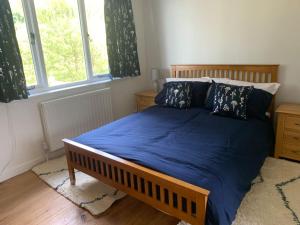 a bedroom with a bed with blue sheets and a window at Cottage with outstanding views in Velindre