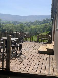 a wooden deck with a table and chairs on it at Cottage with outstanding views in Velindre