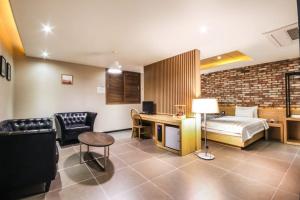 ein Schlafzimmer mit einem Bett und einem Schreibtisch in einem Zimmer in der Unterkunft Hotel Able in Changwon