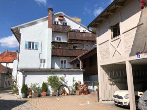 a white building with a balcony on top of it at Altstadt Ferienwohnung Guade Zeit in Füssen