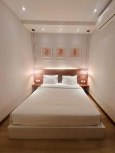 a bedroom with a large white bed with two pillows at oxy suites G-01 at Shop House Meisterstadt Pollux Habibie in Batam Center