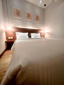ein Schlafzimmer mit einem großen weißen Bett mit zwei Kissen in der Unterkunft oxy suites G-01 at Shop House Meisterstadt Pollux Habibie in Batam Center
