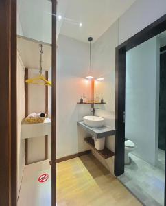 ein Bad mit einem Waschbecken und einem WC in der Unterkunft oxy suites G-01 at Shop House Meisterstadt Pollux Habibie in Batam Center