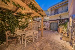 an outdoor patio with a wooden table and chairs at Boutique Cretan house in Old Malia with Jacuzzi in Malia