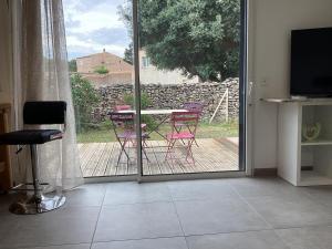 a room with a patio with a table and chairs at La Détente in Bonifacio