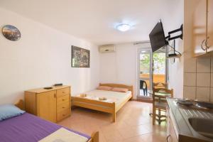 a bedroom with a bed and a kitchen with a table at Apartments Antic in Budva