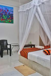 a bedroom with a canopy bed and a chair at Anuradhapura Kingdom View Resort in Anuradhapura