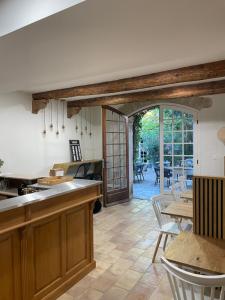 een keuken met houten kasten en een tafel met stoelen bij La Passiflore in Vergèze