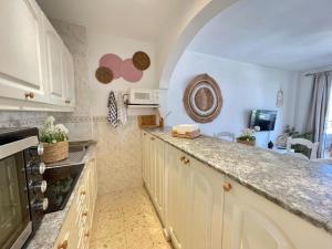 une cuisine avec des armoires blanches et un comptoir dans l'établissement Kitty´s beach house, à Benalmádena 4 autres photos