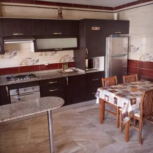 a kitchen with a table and chairs and a refrigerator at 2 minutes from Sheraton Oran. Come and relax here. in Oran