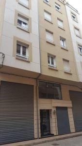 a tall building with garage doors in front of it at 2 minutes from Sheraton Oran. Come and relax here. in Oran
