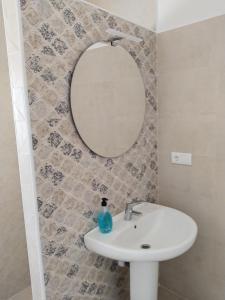 a bathroom with a white sink and a mirror at Casa EDU in Sanlúcar de Barrameda