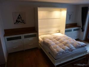 a bedroom with a bed with a headboard and cabinets at FeWo Almherzl mit Hallenbad,Sauna,Panoramablick,renoviert in Missen-Wilhams +36 photos