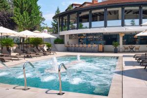a pool at a hotel with chairs and a bar at Viva Mare Beach Hotel by Santa Marina in Sozopol
