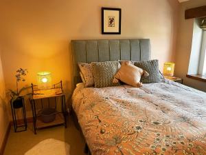 1 cama en un dormitorio con 2 lámparas y 1 cama sidx sidx sidx sidx en Honeysuckle Cottage en Longnor