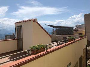 a balcony with potted plants on top of a building at Casa indipendente nel centro storico,cod IUN P2680 in Baunei +7 photos