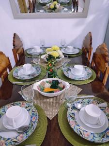 una mesa de comedor con platos y platos. en Koze De Casa Newly Renovated Staycation, en Imus