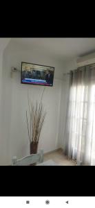 a tv hanging on a wall in a living room at Ira Apartments in Kamari