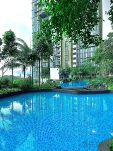 a large blue swimming pool with tall buildings in the background at Elysia Park Residence Medini by Stayrene in Nusajaya