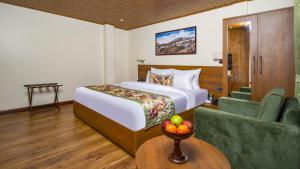 une chambre d'hôtel avec un lit et une chaise dans l'établissement Mount Lungta Boutique Hotel & Spa, à Darjeeling
