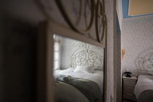 Schlafzimmer mit einem weißen Bett und einem Spiegel in der Unterkunft Boutique Hotel Anagennisis in Pýrgos