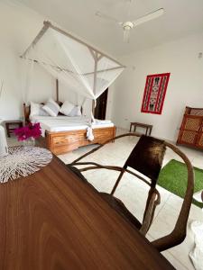 a bedroom with a bed with a canopy at Shamba Lodge in Nungwi