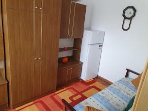 a small kitchen with a refrigerator and wooden cabinets at Apartament Codruta in Turda