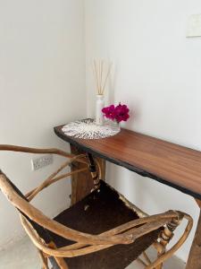 un tavolo di legno con un vaso di fiori sopra di Shamba Lodge a Nungwi