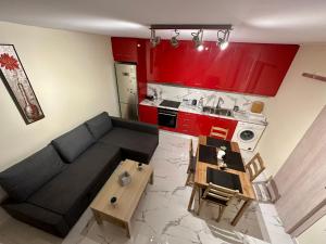 a living room with a black couch and red cabinets at Red Harmony by the sea Pool and balcony in Kalamata